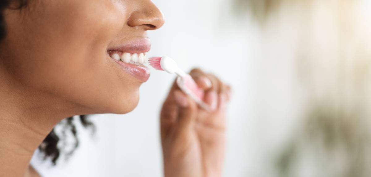 Woman brushing her teeth with Invisalign.